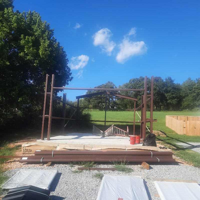 A wooden structure is being built in a field