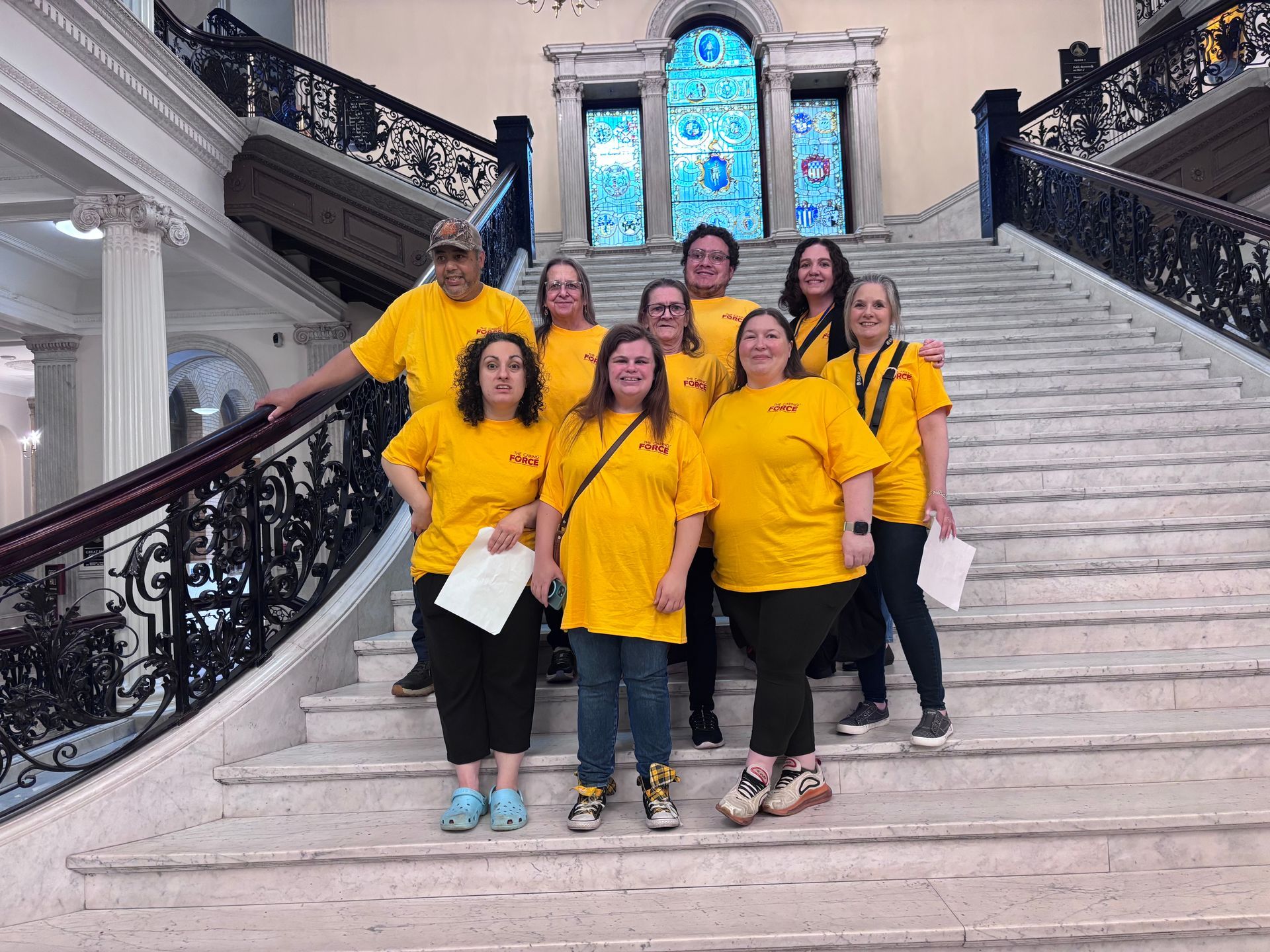 A group of BFAIR staff and individuals in yellow shirts at the Caring Force Rally in Boston