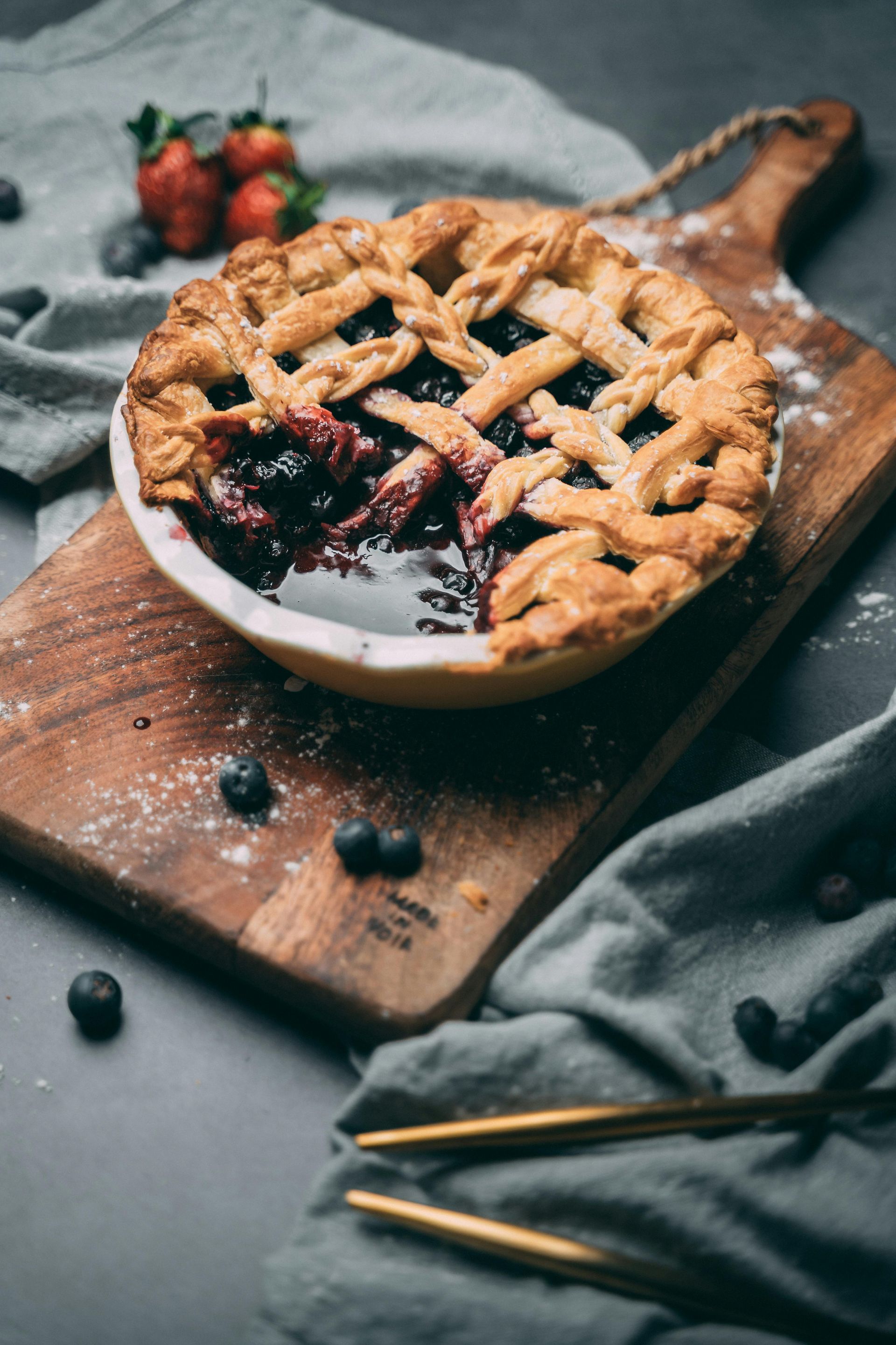 A blueberry pie fresh baked out of the oven with a piece missing