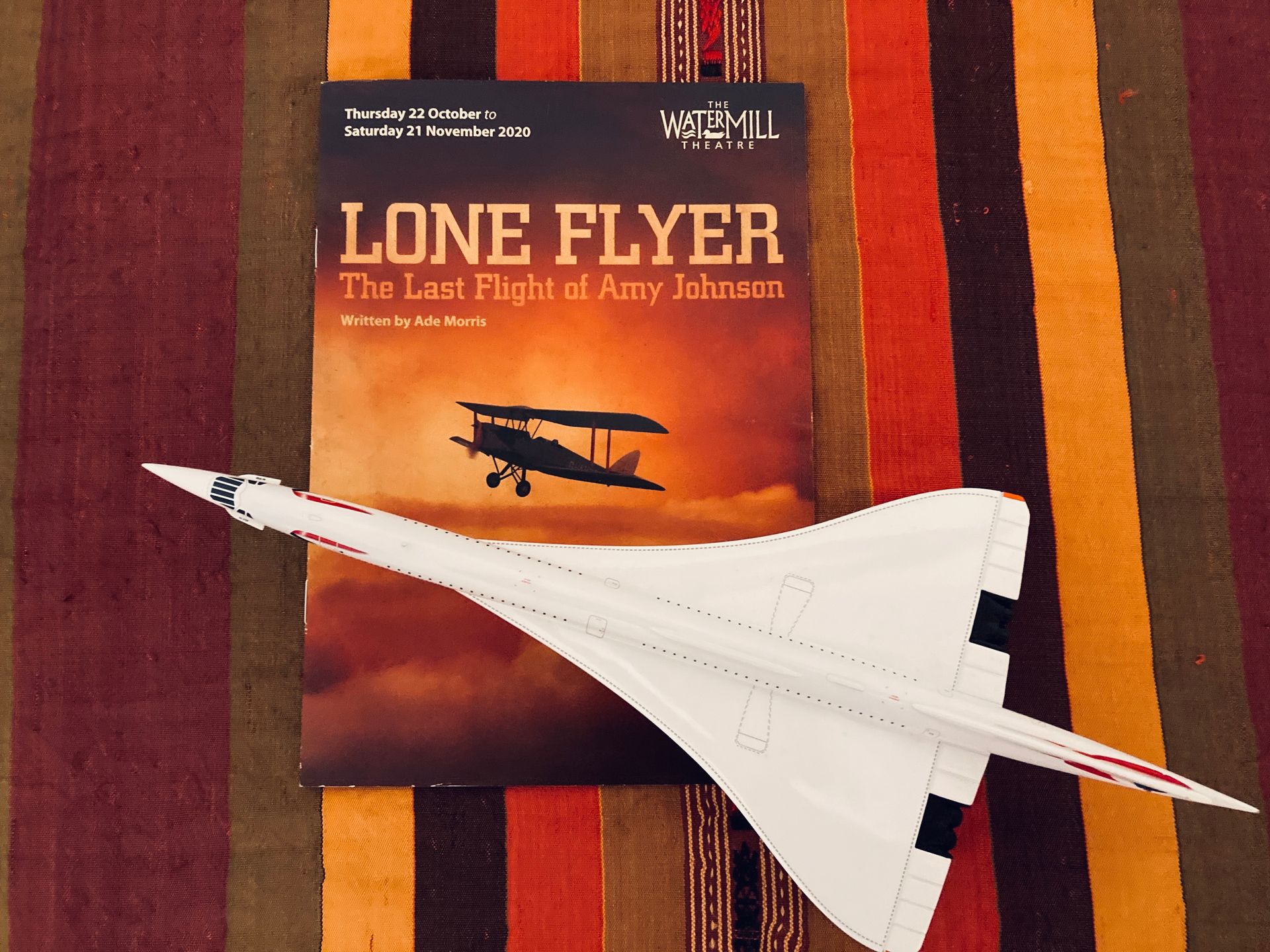 A paper model of a Concorde jet rests on a program for the play 