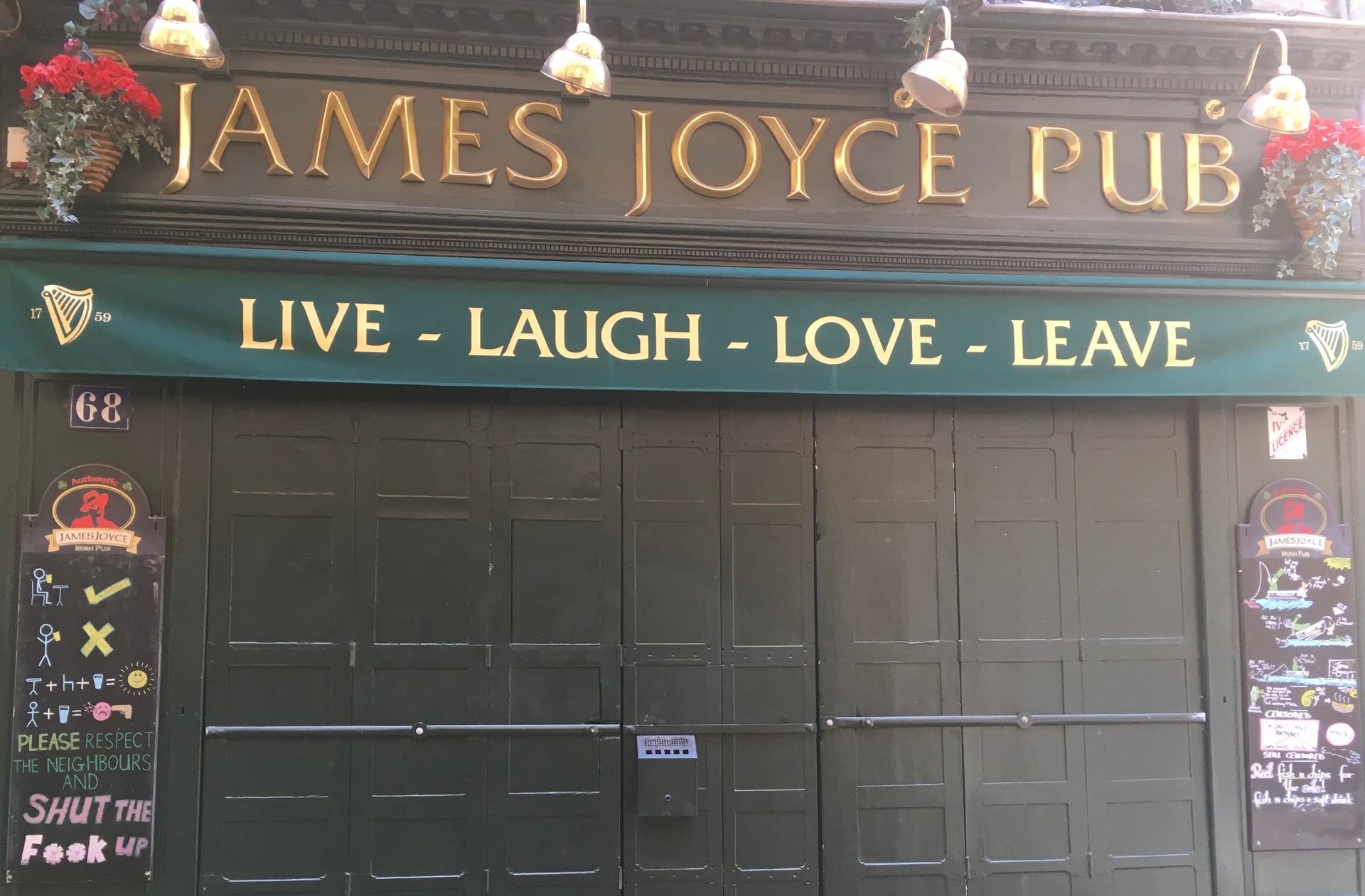 A dark-fronted James Joyce Pub with a green awning that reads 
