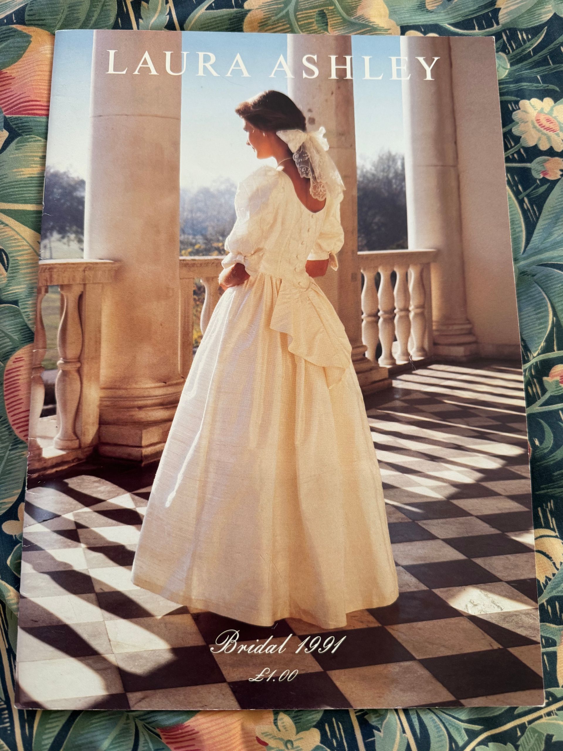 A bride in a vintage white gown stands on a sunlit terrace with columns and a checkered floor, titled 