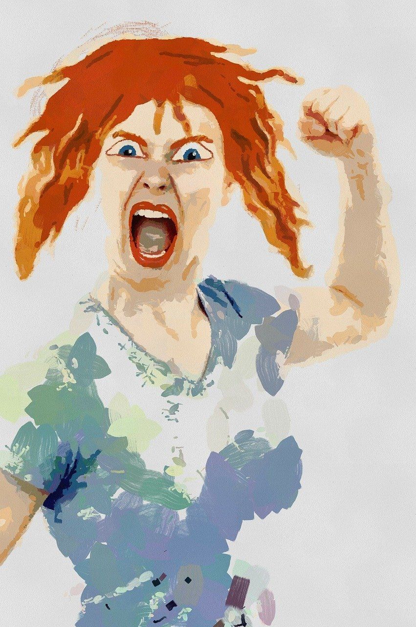 A person with bright red hair yelling with an angry expression, raising one fist in the air.