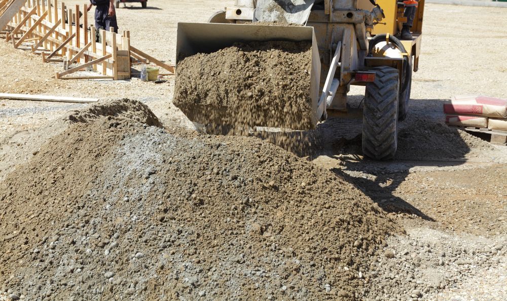 A Tractor Dumping Gravel Onto a Pile at a Construction Site — Australian Sandstone Products In Dalby, QLD