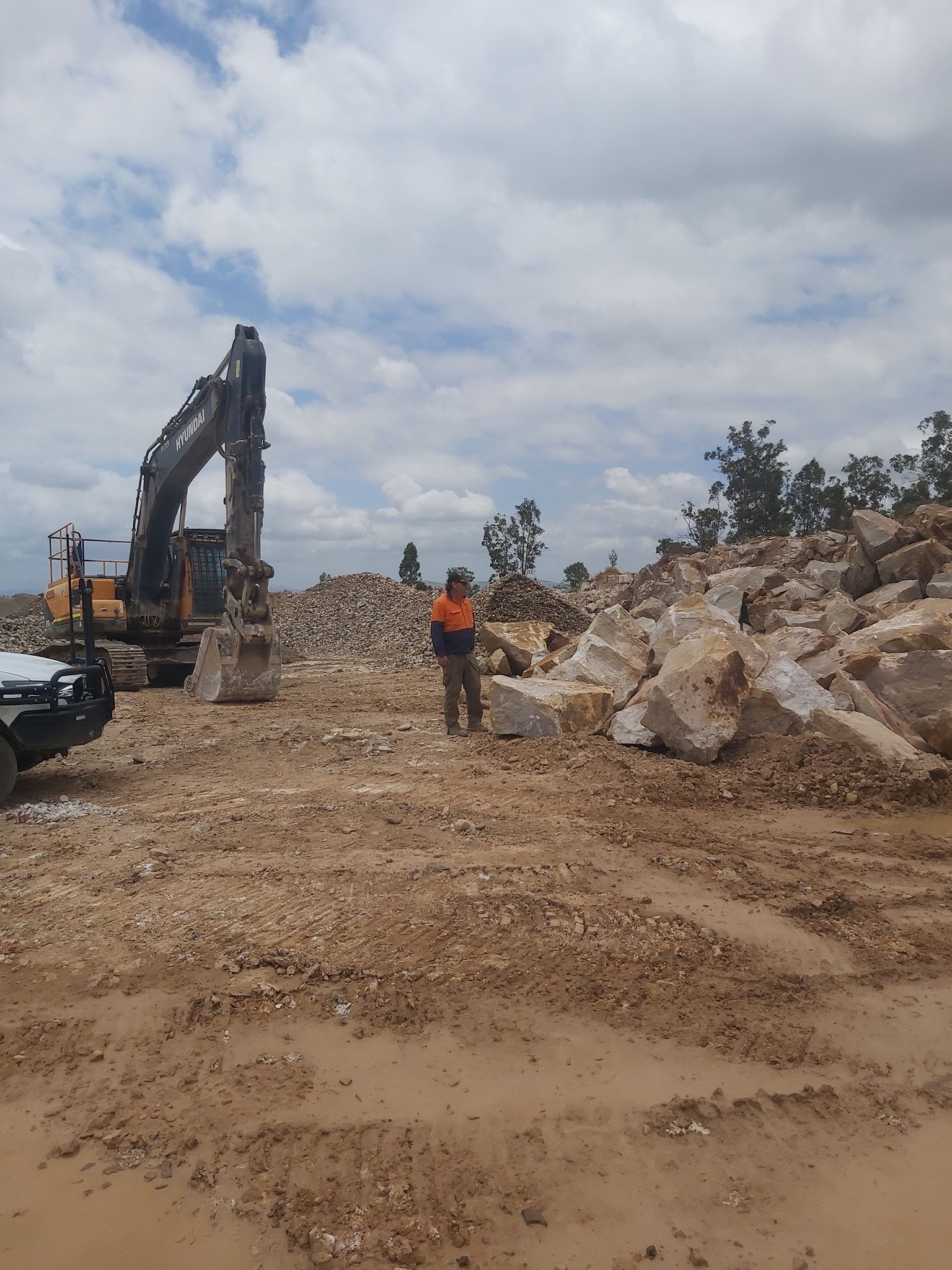 A Person in an Orange Vest Stands in a Quarry — Australian Sandstone Products In Toowoomba, QLD