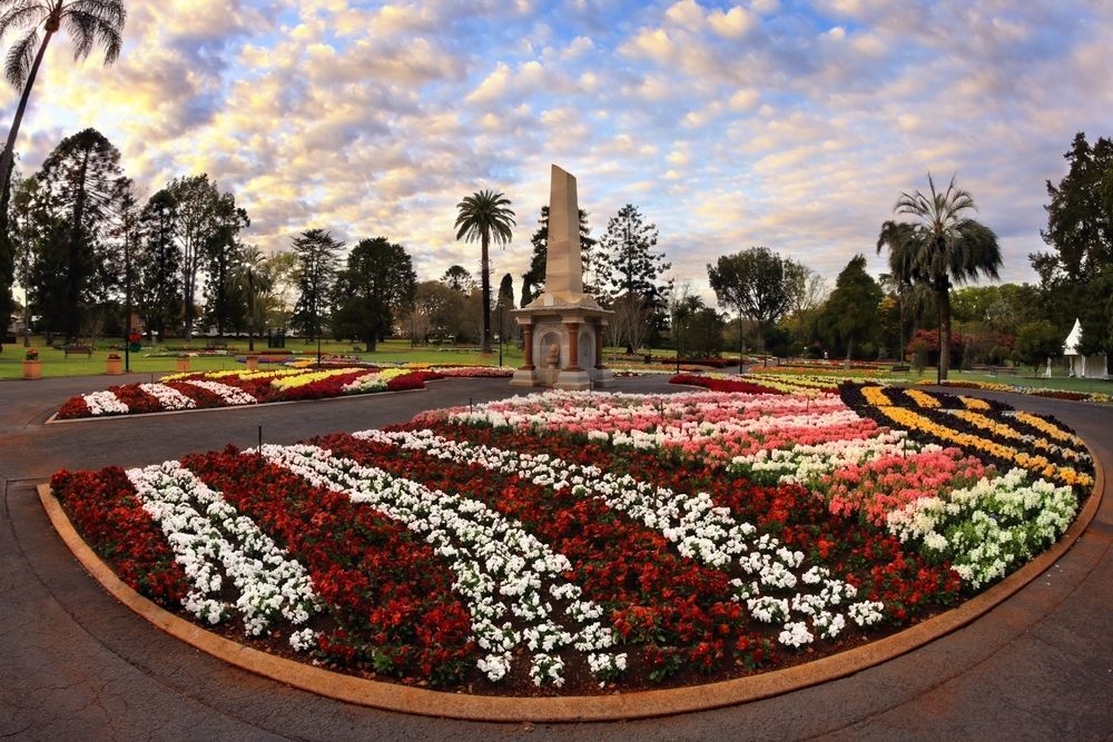 A Circle Of Flowers In A Park With A Statue In The Background — Australian Sandstone Products In Toowoomba, QLD