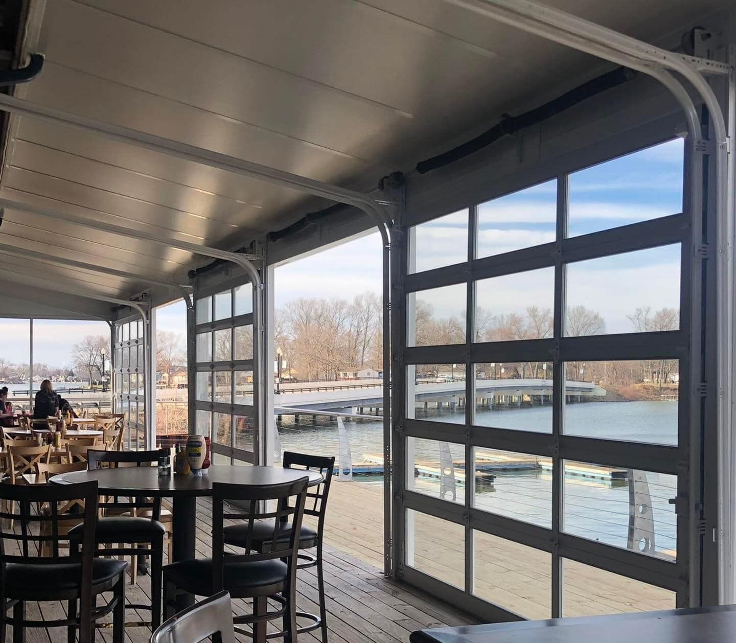 A restaurant with tables and chairs overlooking a body of water
