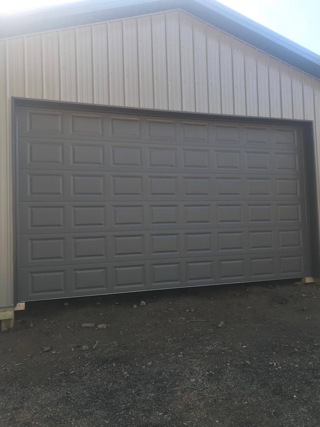 A large garage door is open in a garage.