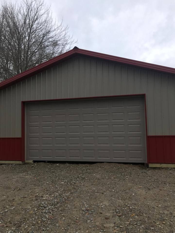 A garage with a large garage door and a red roof