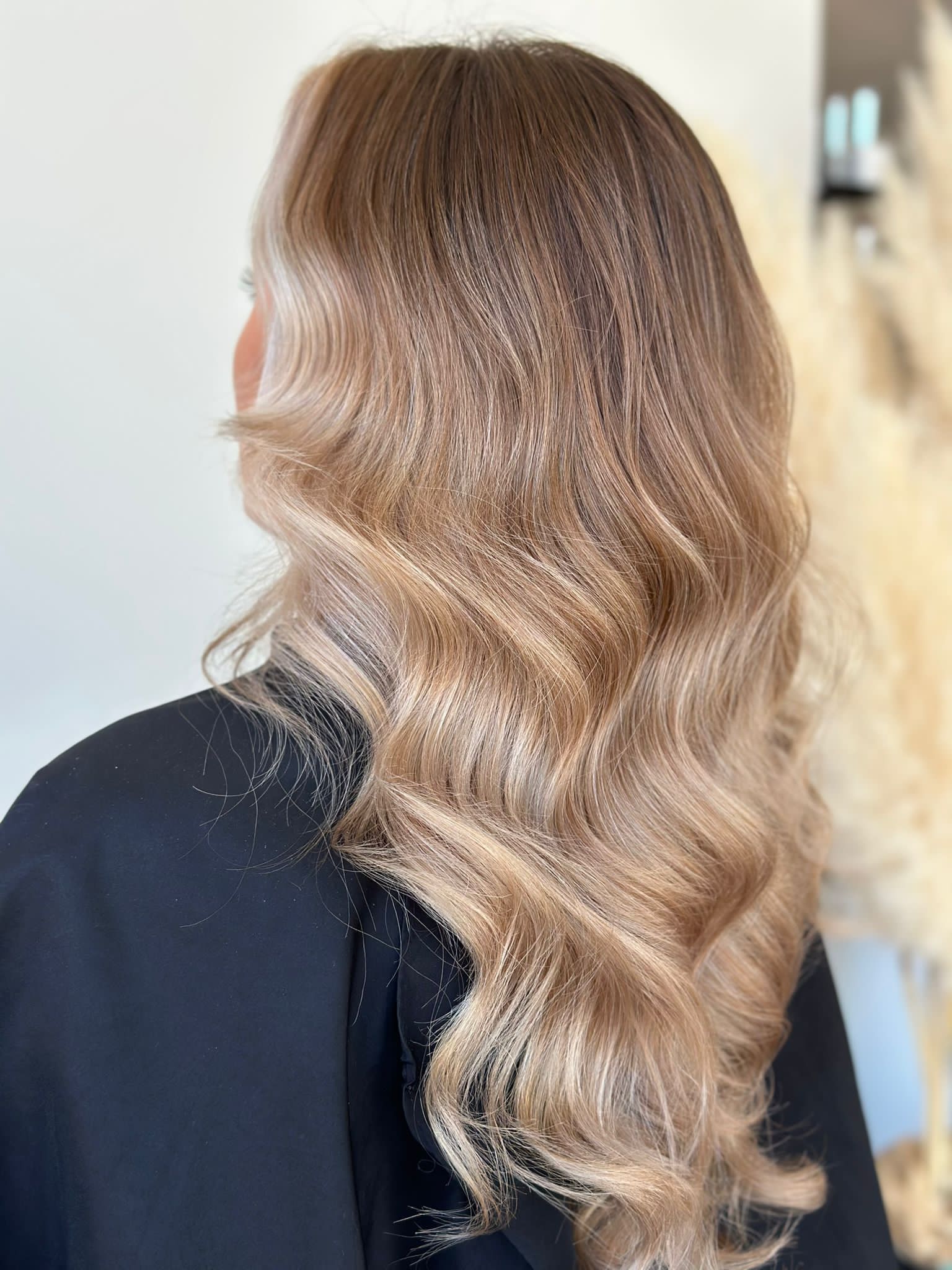 A back view of long, light brown hair styled with prominent, tight crimped waves.