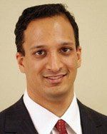 A man in a suit and tie is smiling for the camera.