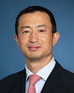 A man in a suit and tie is smiling for the camera.