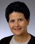 A woman with short black hair is smiling for the camera.
