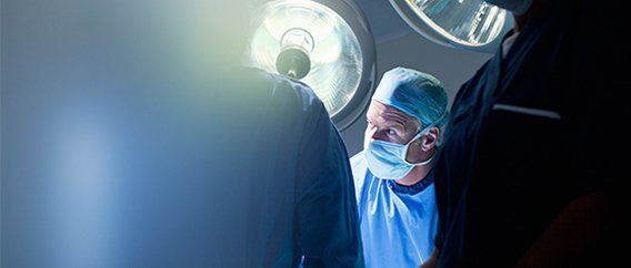 A surgeon is talking on a cell phone in an operating room.