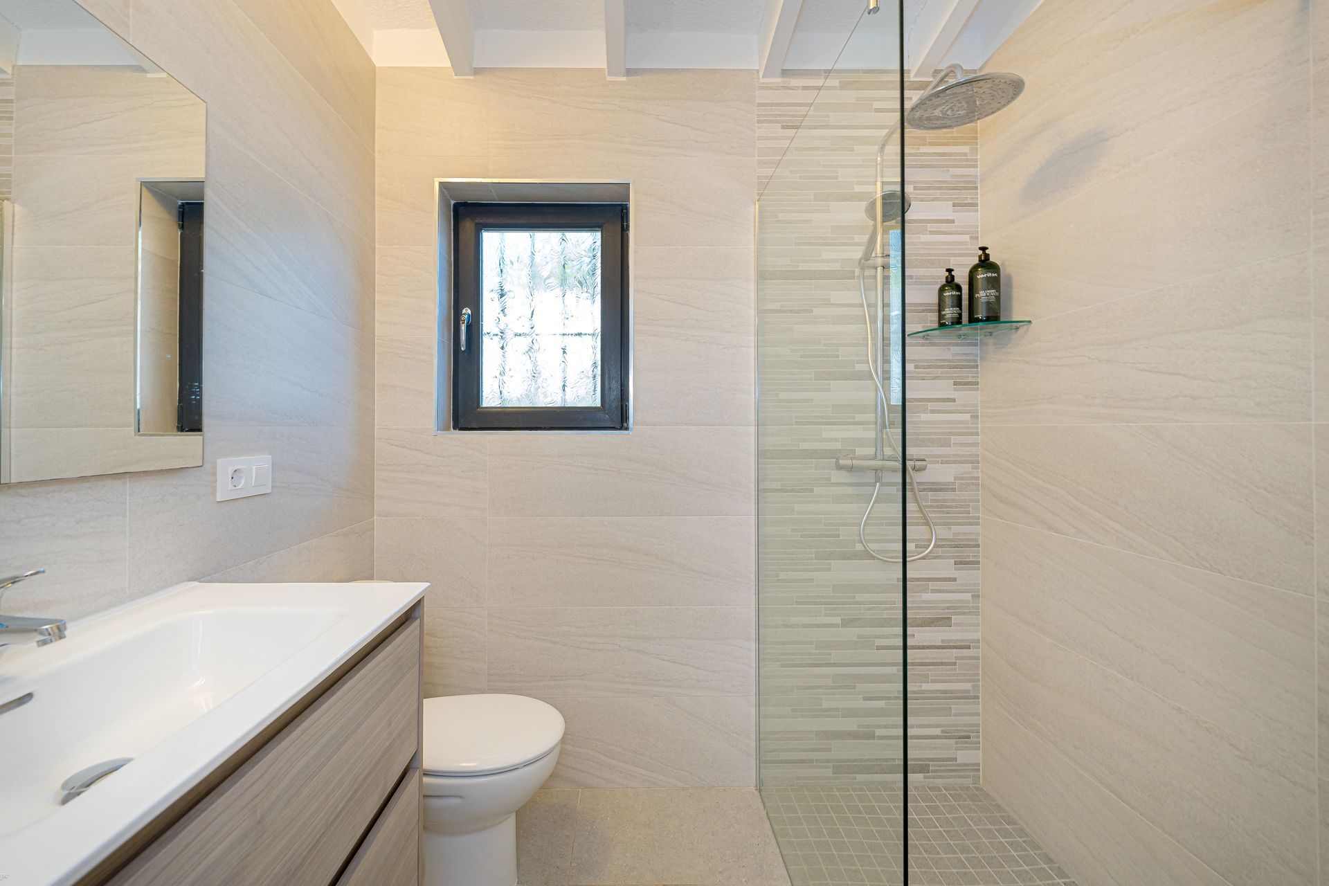 Luxe badkamer van Villa Fio met ruime inloopdouche, modern badkamermeubel en veel daglicht.