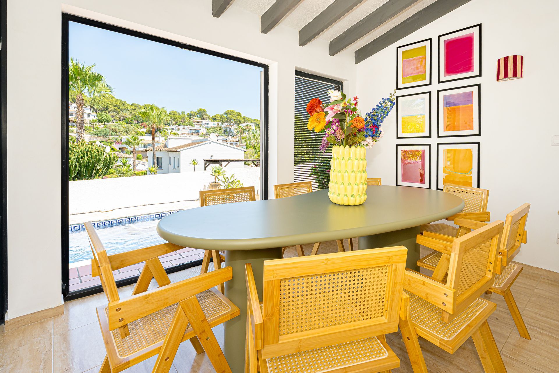 Moderne eetkamer van Villa Fio met uitzicht op het verwarmde zwembad en de tuin in Moraira.