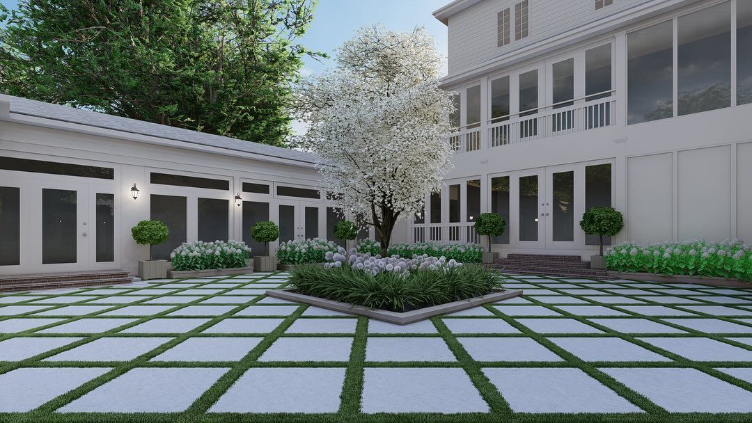 Modern courtyard with stone pavers, a central planter, and white buildings surrounding a green space