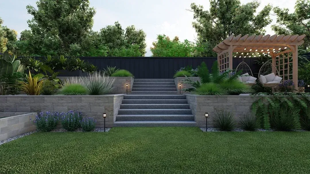 Landscaped backyard with stone steps, retaining walls, greenery, and a wooden pergola