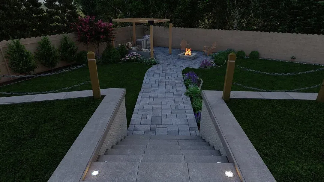 Stone steps lead to a landscaped backyard path with grass, shrubs, and a small fire feature at dusk