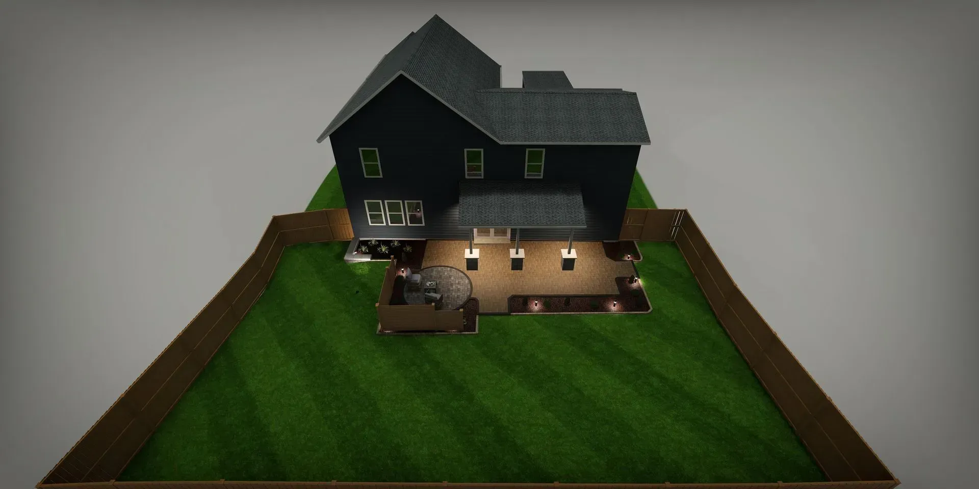 Small black house with lit windows on a grassy lot, viewed from above.