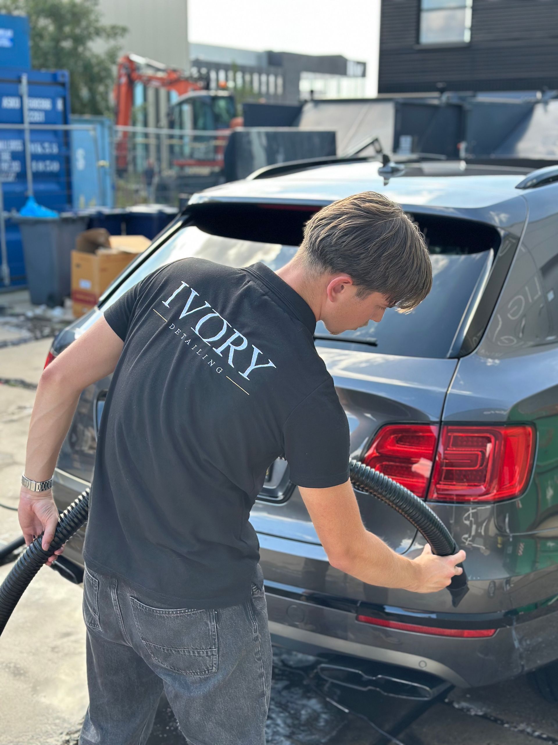 Het afspuiten van een grijze Land Rover Velar. Car cleaning op locatie.