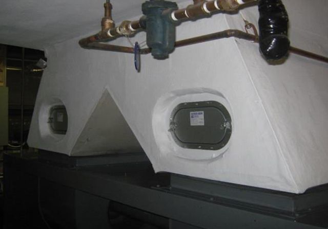 Il y a beaucoup de tuyaux suspendus au plafond d'un bâtiment.