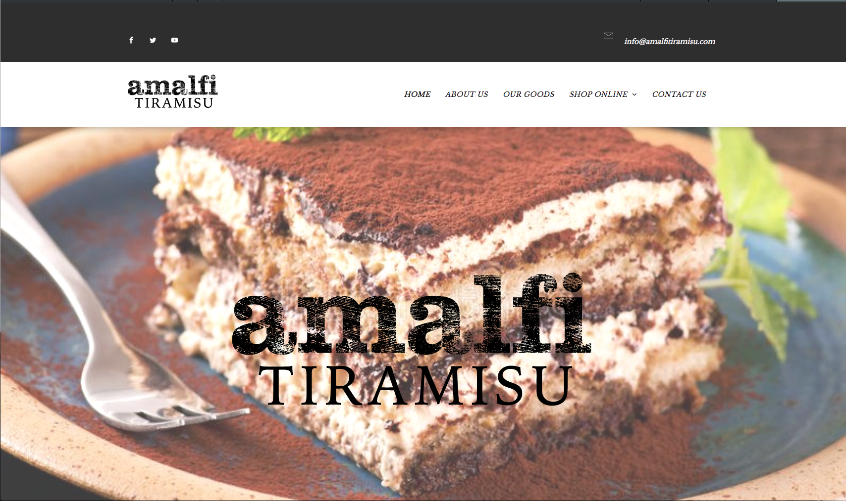 Amalfi Tiramisu: A close-up of layered tiramisu dusted with cocoa powder, on a blue plate, fork on the side.