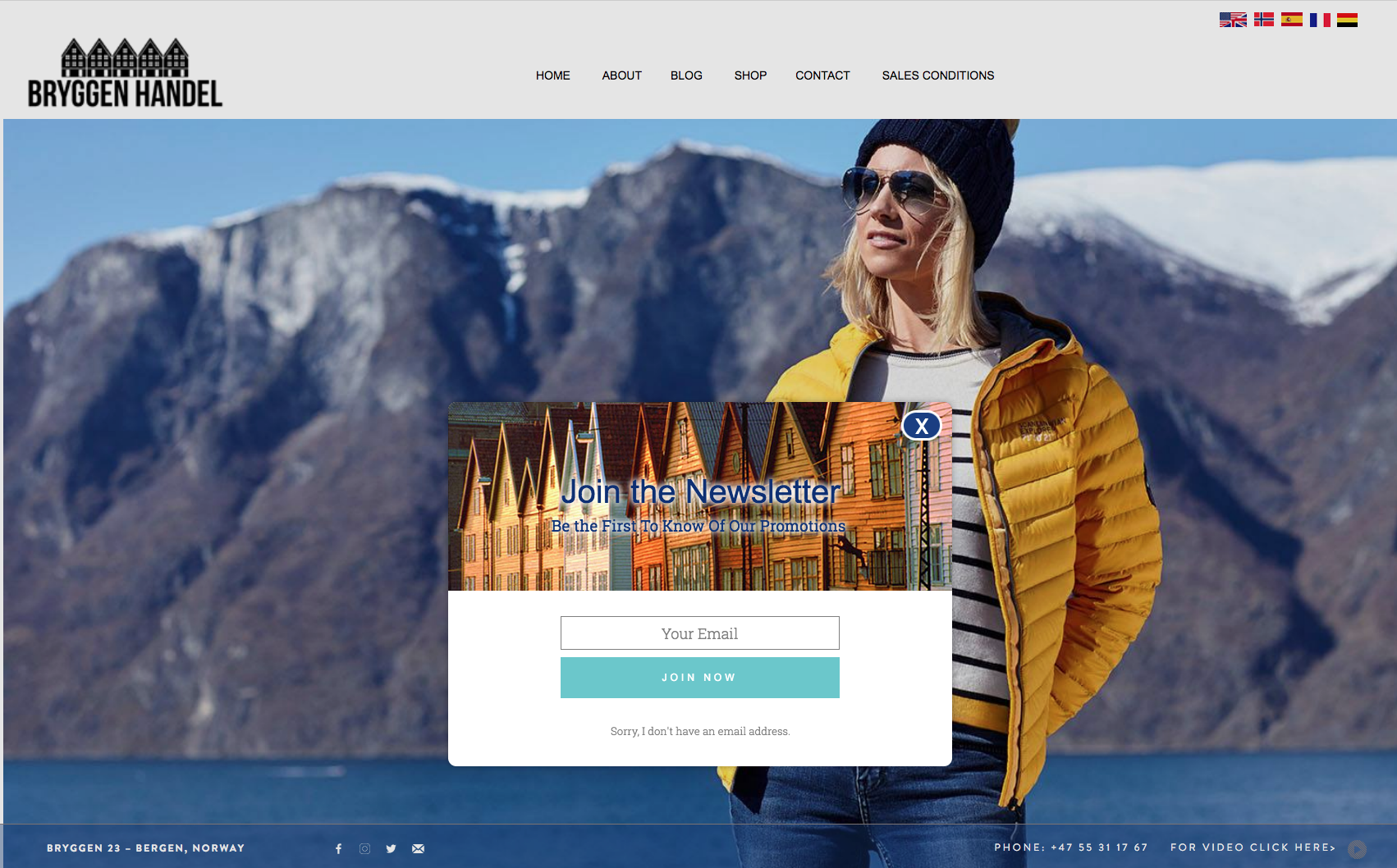 Woman in yellow jacket and black hat in front of a snowy mountain landscape. Website welcome modal with a turquoise button.