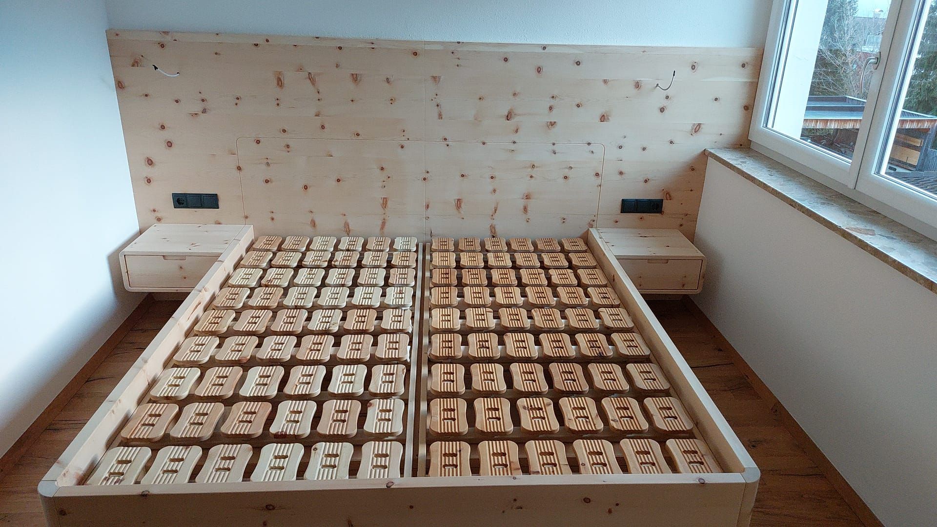 Ein hölzernes Bettgestell in einem Schlafzimmer