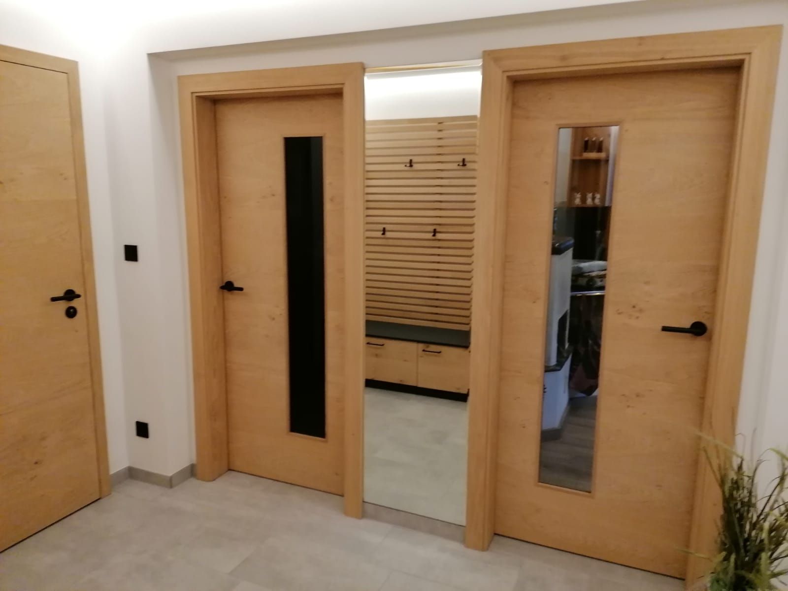 Drei helle Holztüren mit schwarzen Beschlägen