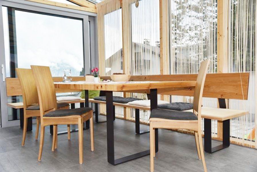 Eine moderne Essgruppe mit hellem Holztisch, schwarzen Metallbeinen
