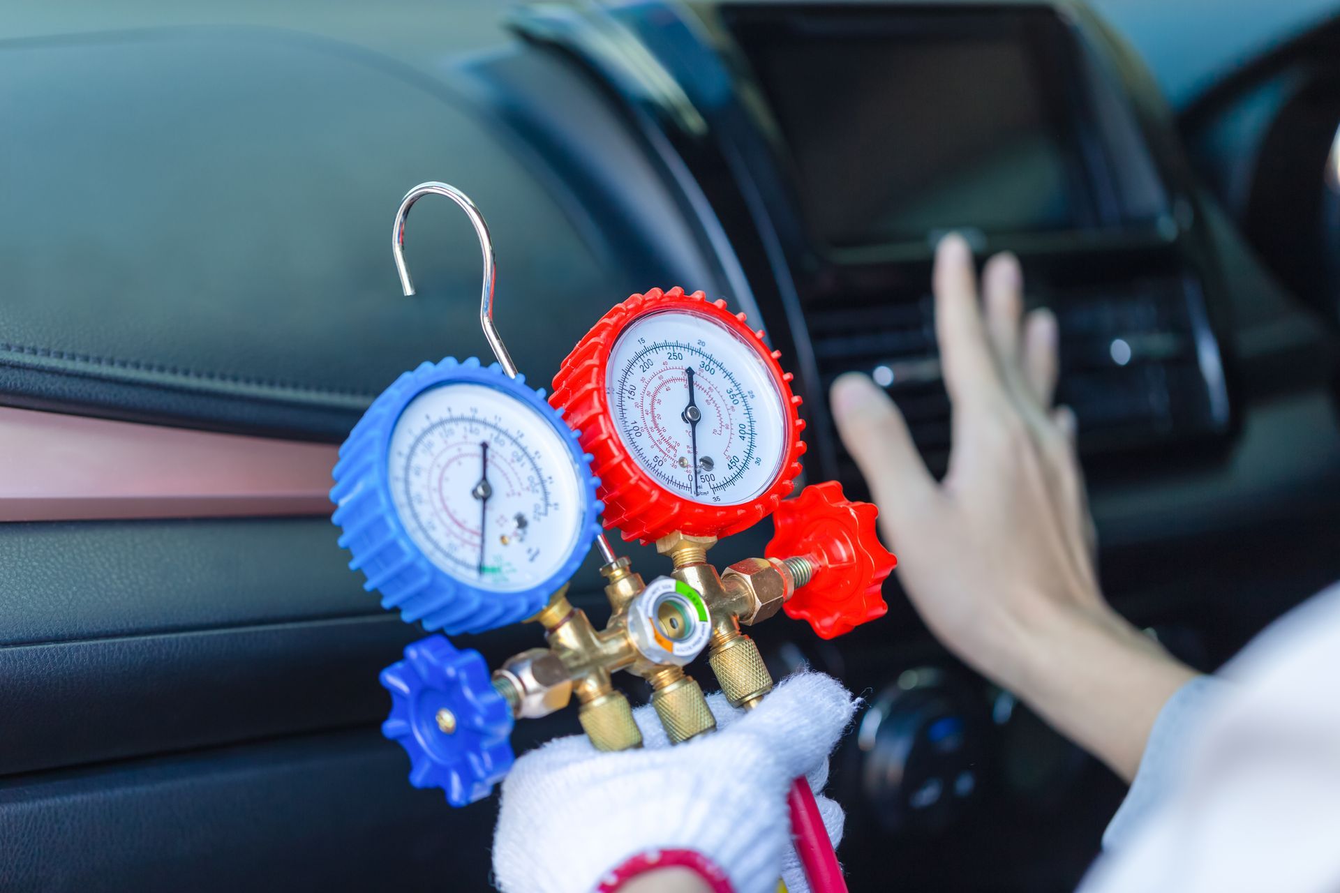 Colorful car dashboard ornaments with blue and red dials beside a hand on the steering wheel