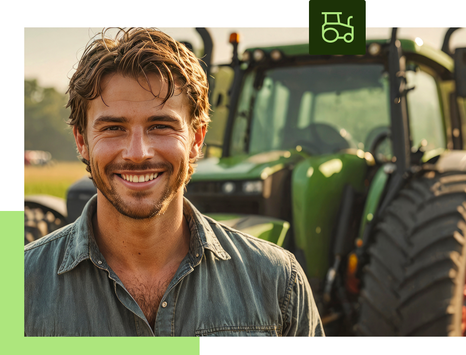 Smiling farmer in a field with green tractor.