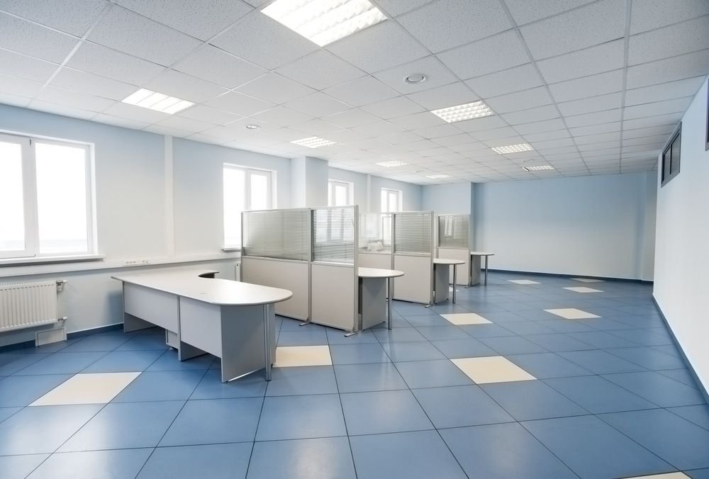 An Empty Office With Blue Tile Floors And Cubicles — In Electrics In Innisfail, QLD