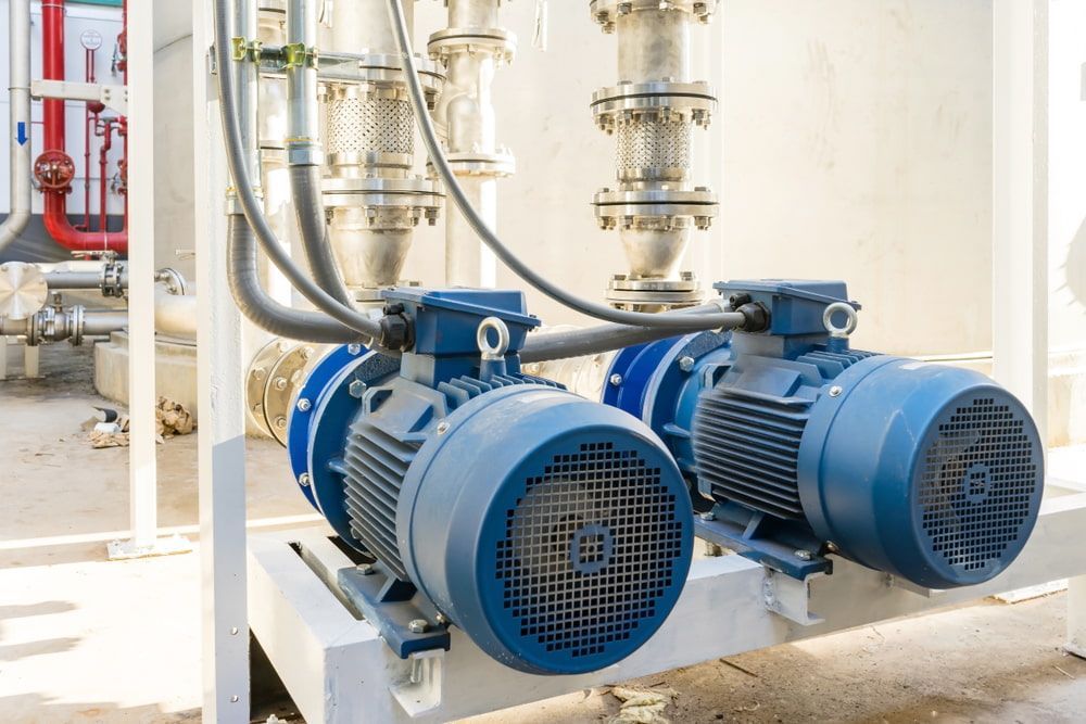 Two Blue Electric Motors Are Sitting Next To Each Other In A Factory — In Electrics In Babinda, QLD