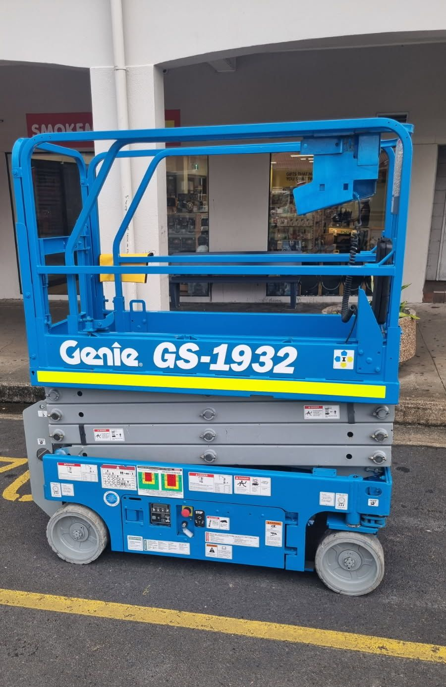 A Man Is Working On A Scissor Lift At A Construction Site — In Electrics In Mission Beach, QLD
