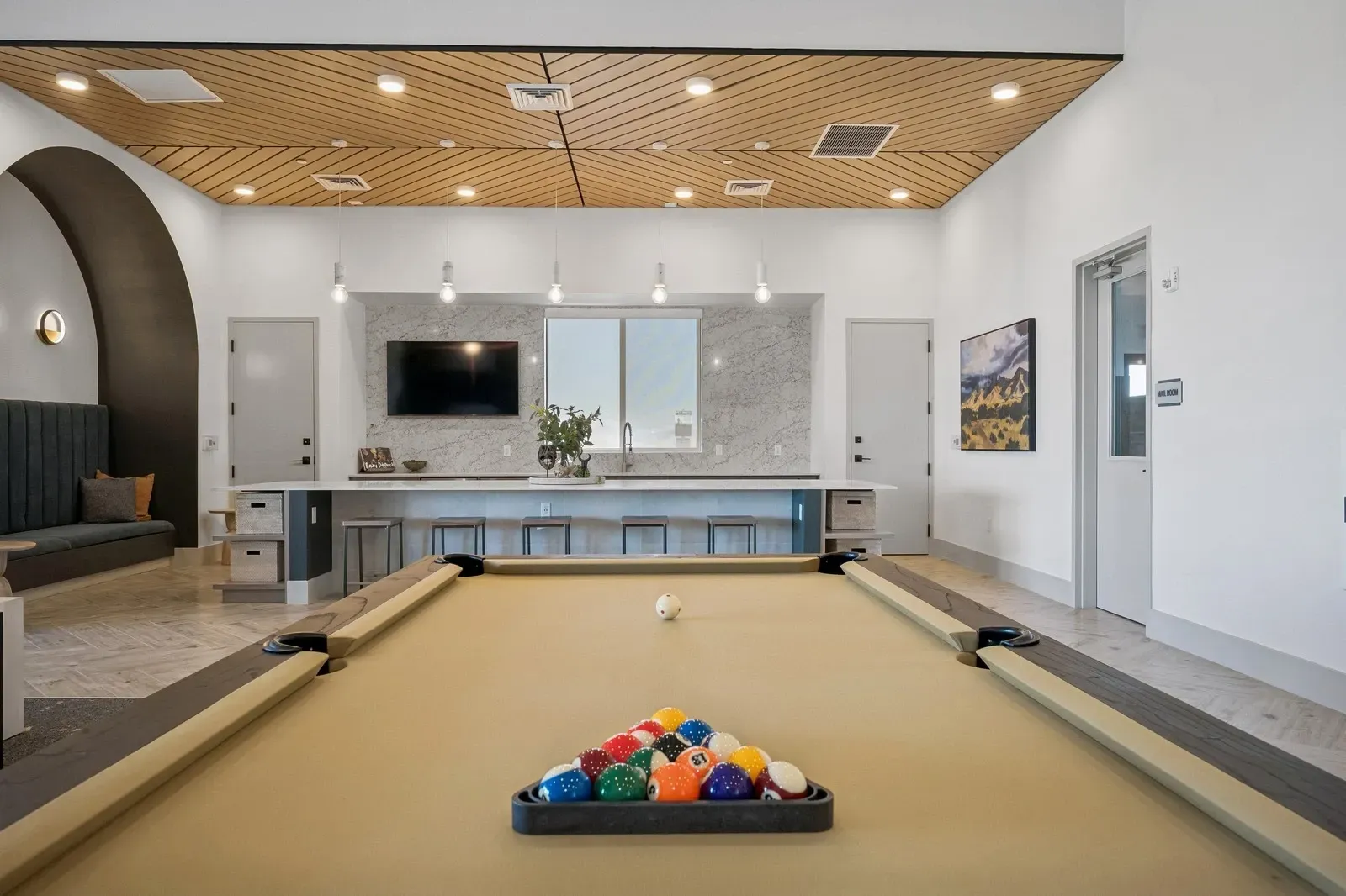 Pool table in a modern lounge area with a bar and seating at Longbow Luxury Apartments Mesa, AZ.