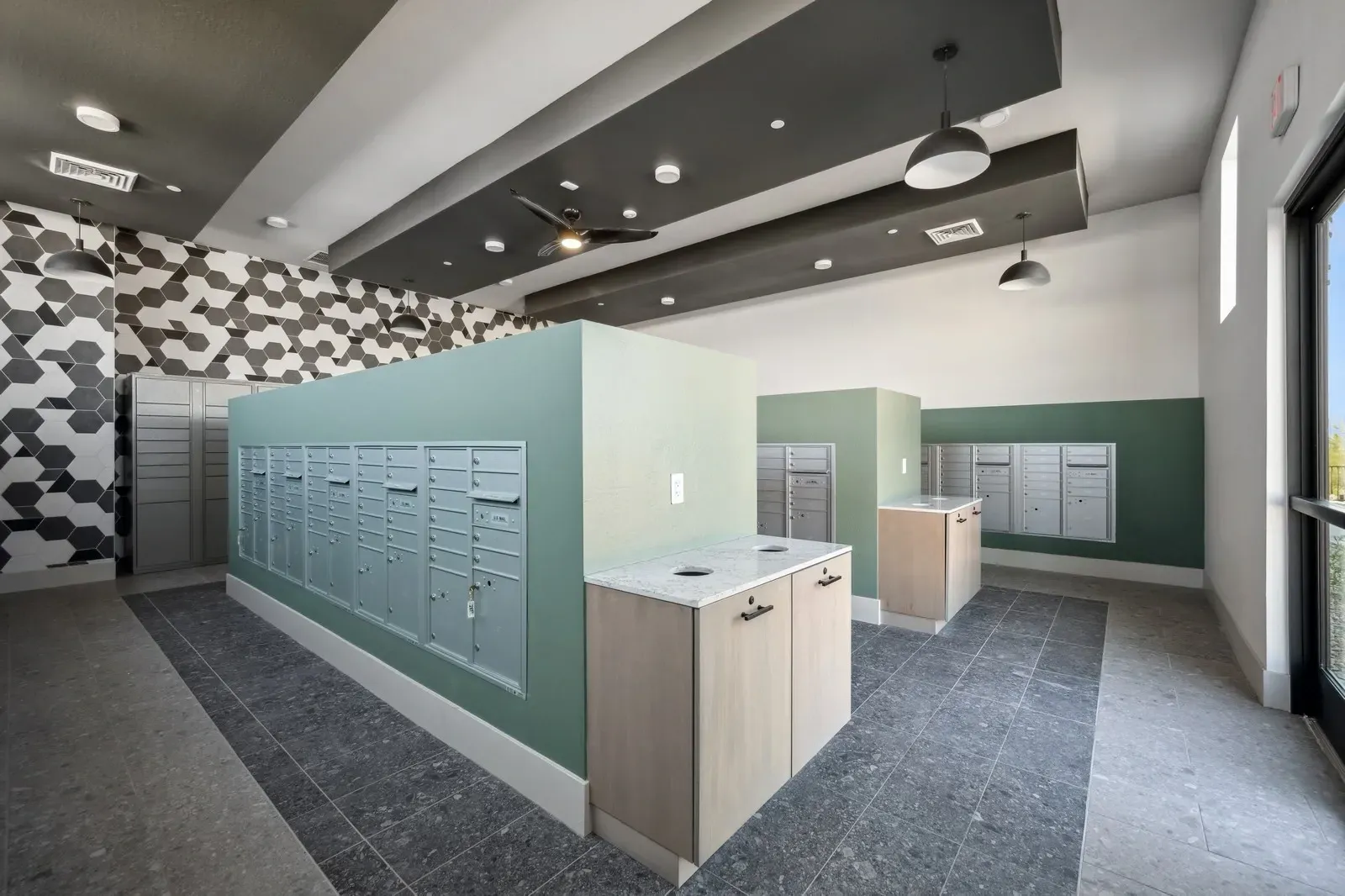 Mailroom with multiple rows of mailboxes and a decorative accent wall at Longbow Luxury Apartments Mesa, AZ.