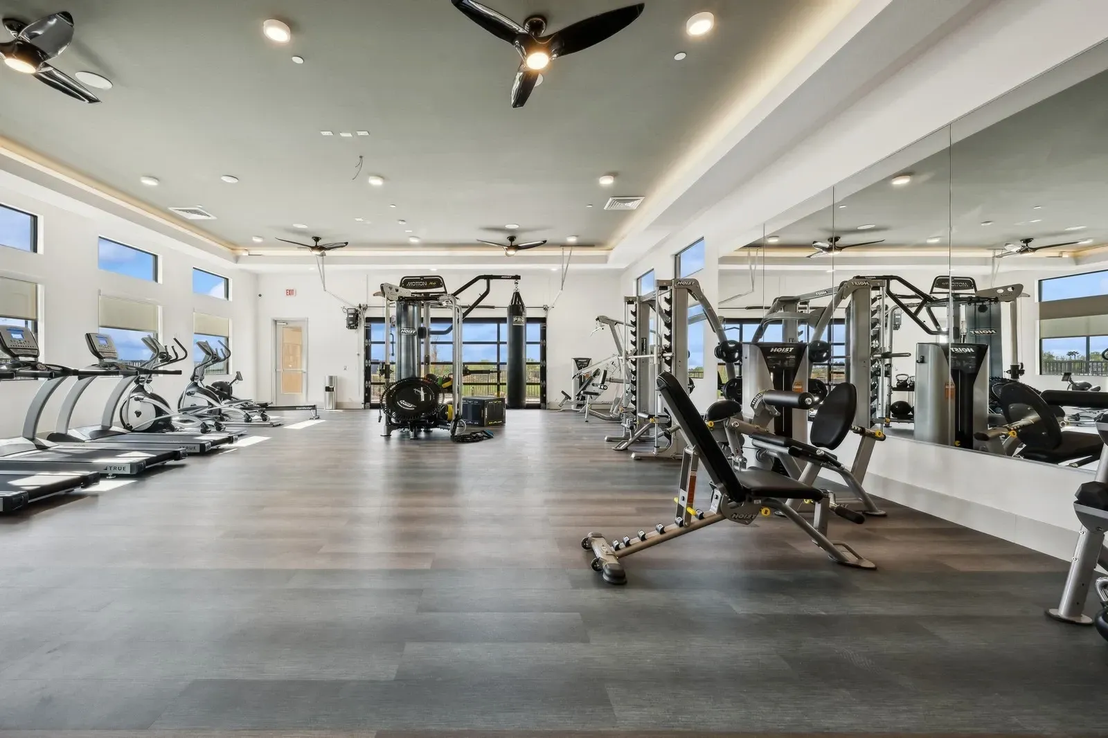 Gym with treadmills, ellipticals, weight machines, and a punching bag.