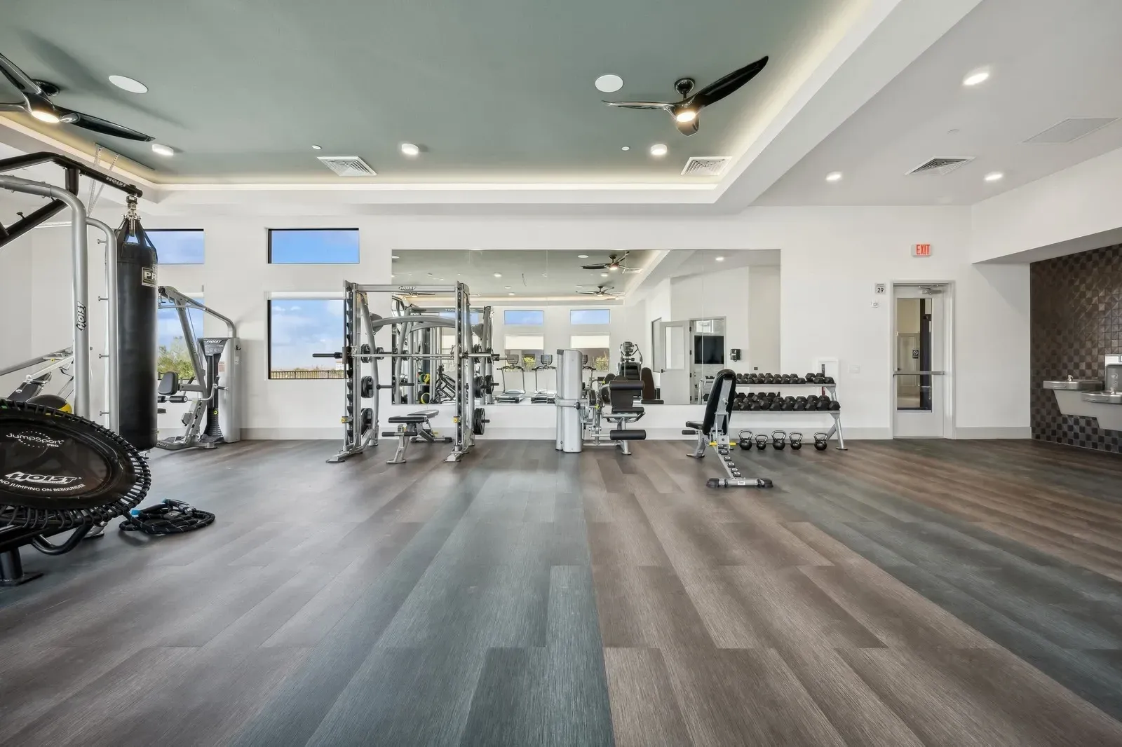 Spacious gym with weightlifting equipment, treadmills, punching bag, and free weights at Longbow Luxury Apartments Mesa, AZ.