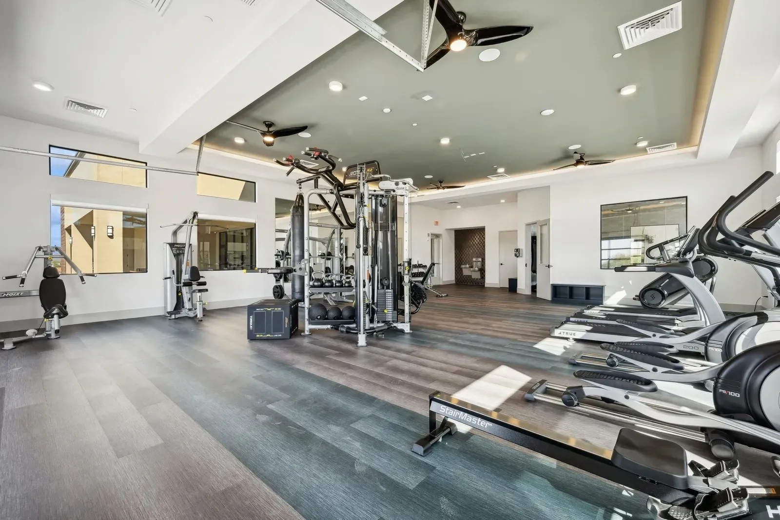 Fitness center with treadmills, ellipticals, rowing machine, and weight machines at Longbow Luxury Apartments Mesa, AZ.