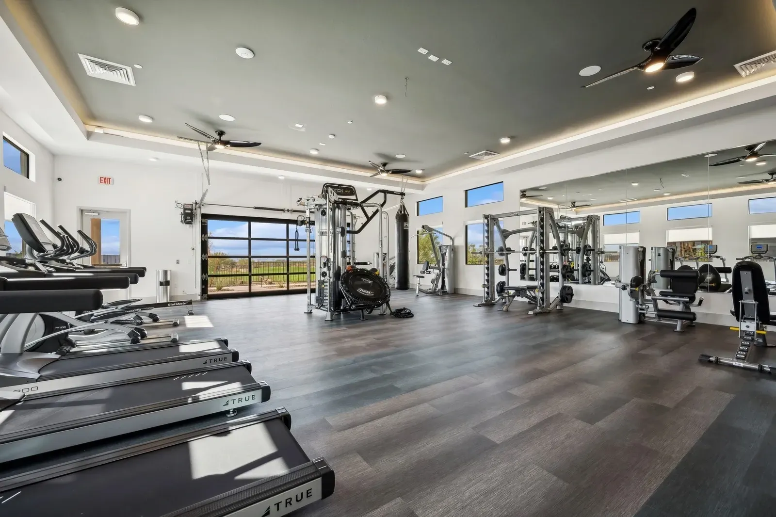 Gym with treadmills, weight machines, punching bag, and large mirrors.