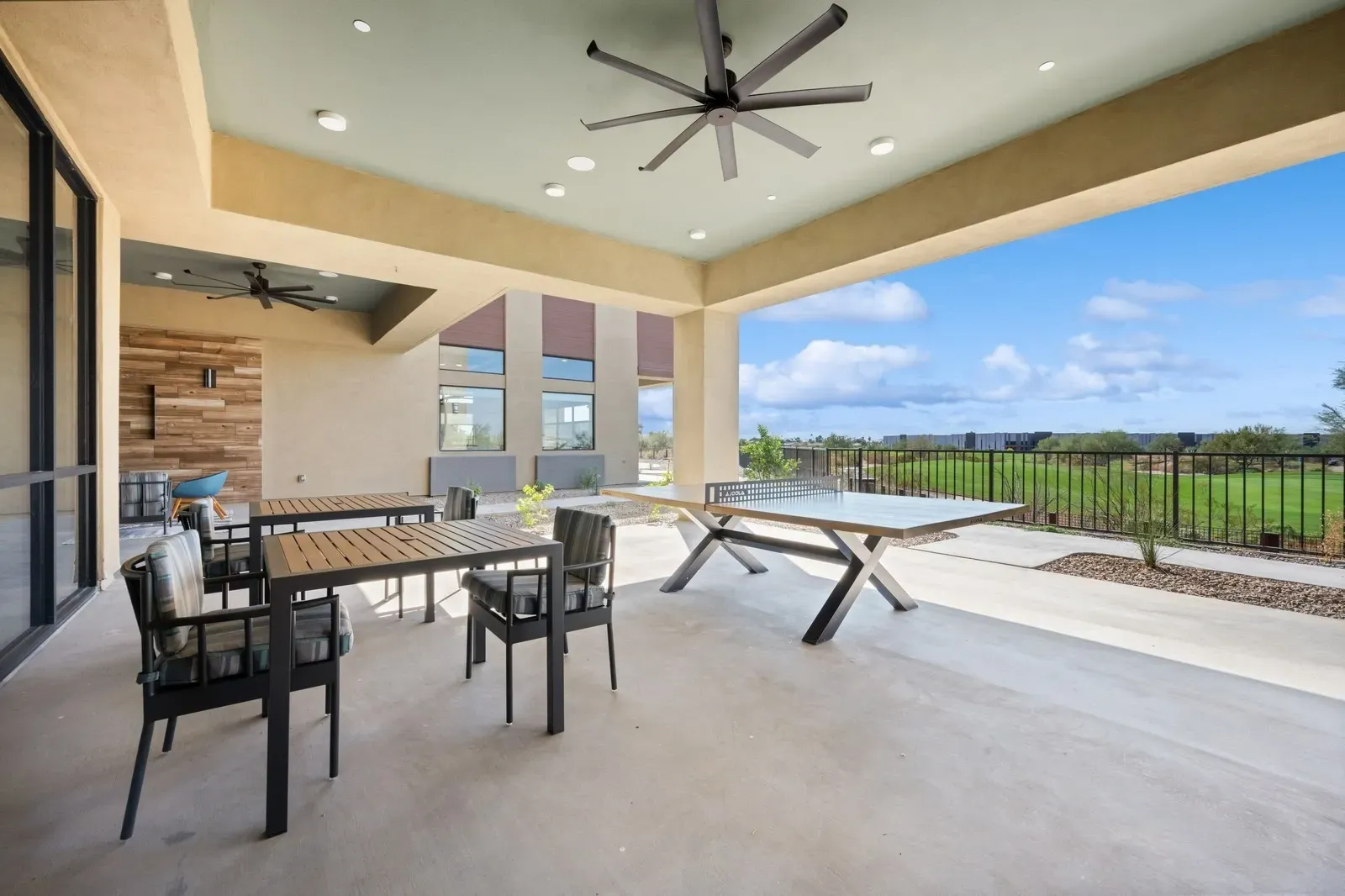 Covered patio with ping pong table and seating area overlooking a golf course at Longbow Luxury Apartments Mesa, AZ.
