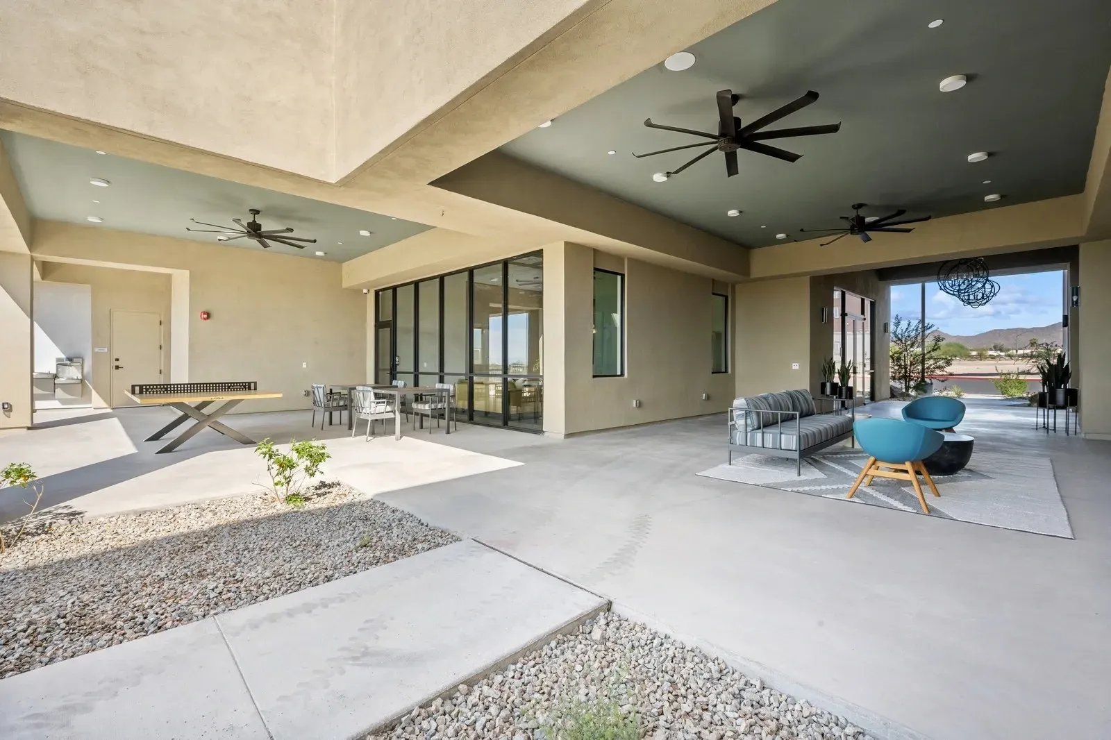 Outdoor lounge area with seating, ping pong table, and tables at Longbow Luxury Apartments Mesa, AZ.