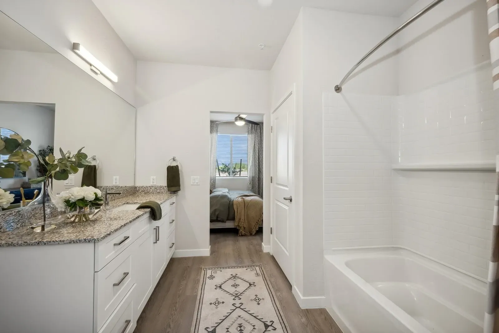 Bathroom with double vanity, large mirror, and bathtub.