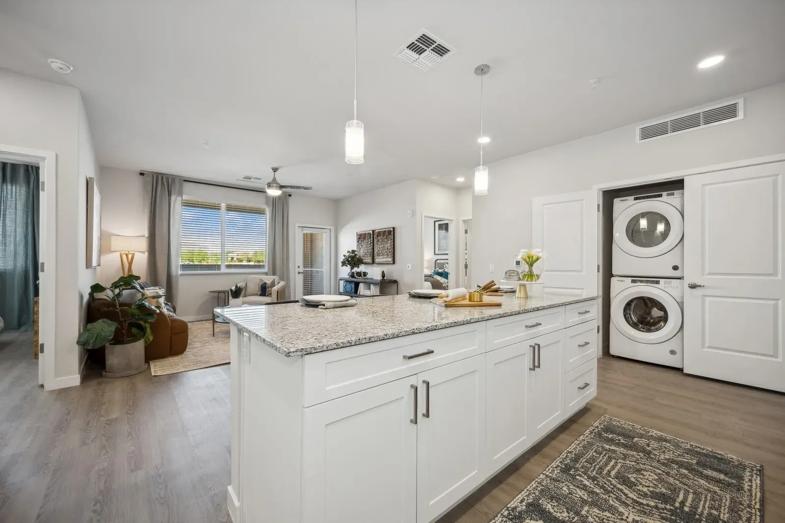 Modern kitchen with island, living room, and in-unit laundry.
