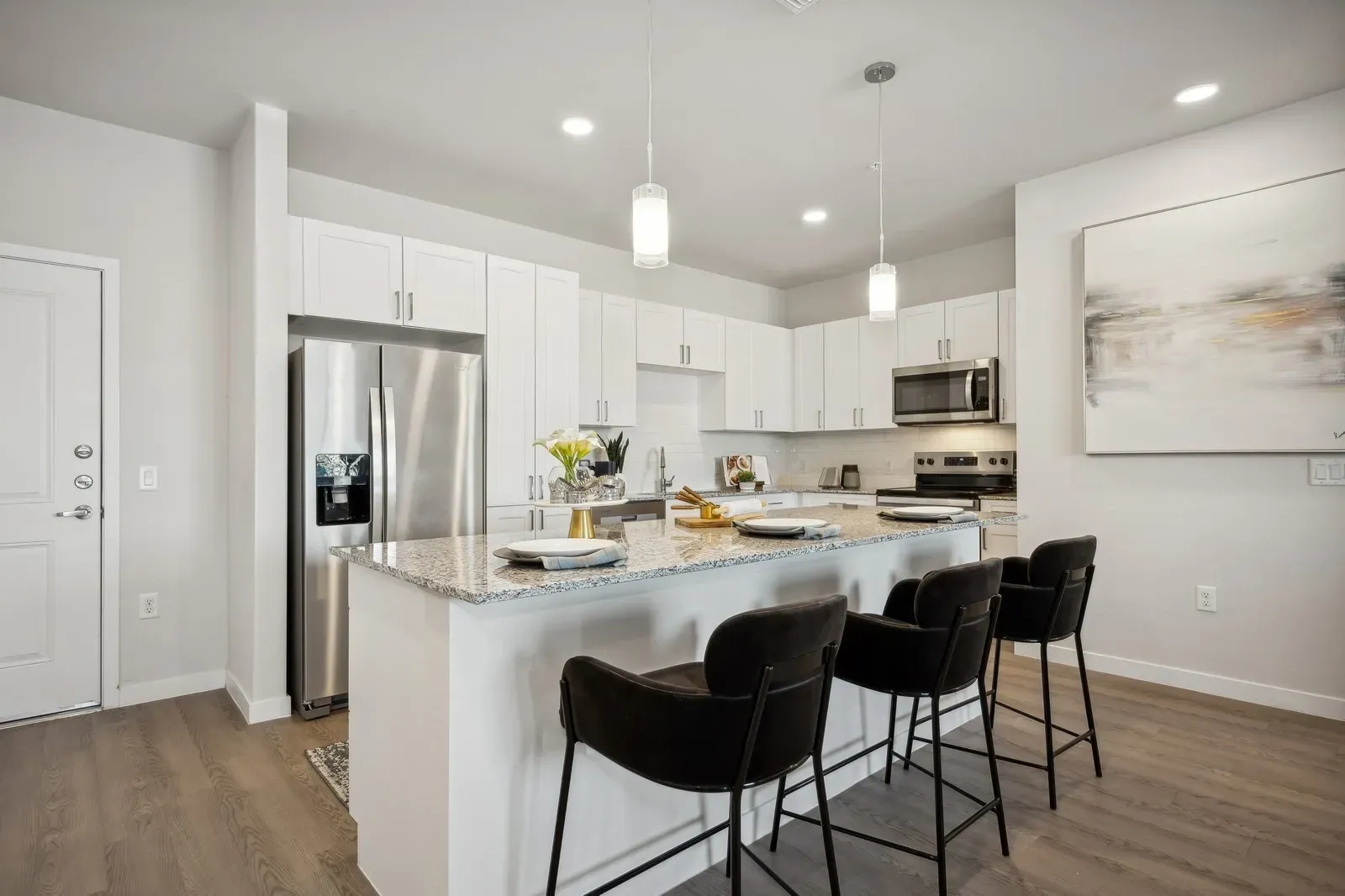 Modern kitchen island with bar stools and granite countertops at Longbow Luxury Apartments Mesa, AZ.