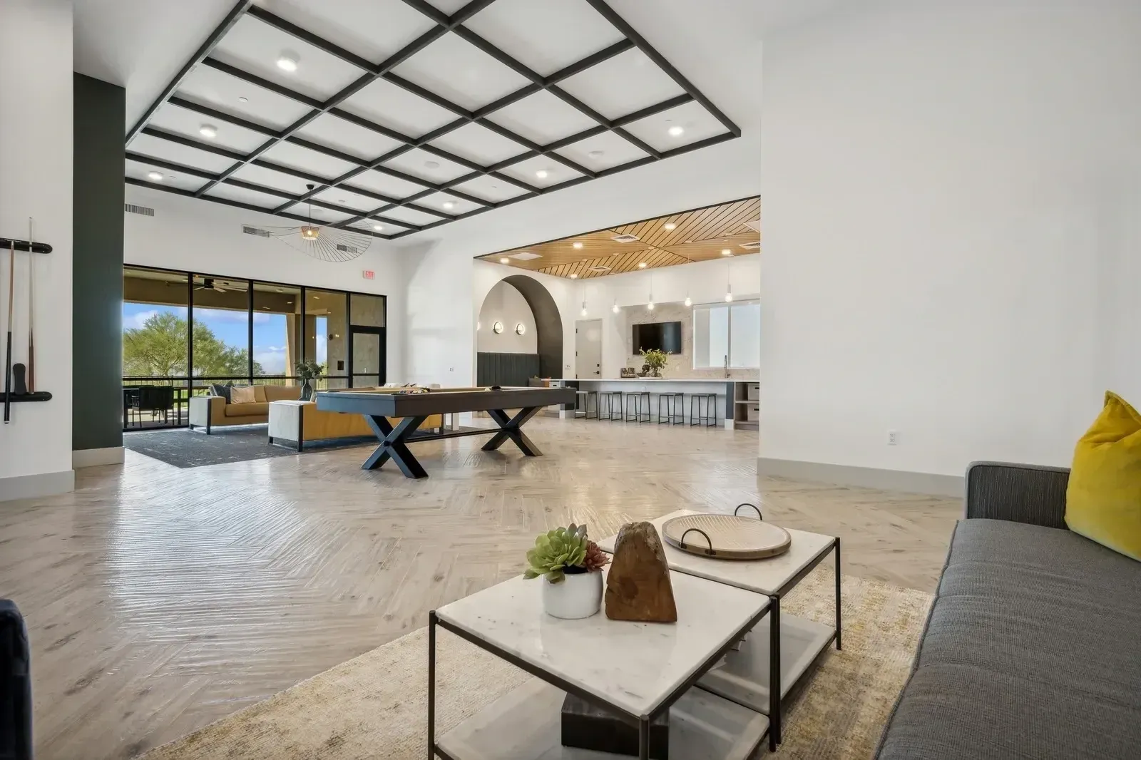 Spacious community lounge with a pool table, seating area, and bar at Longbow Luxury Apartments in Mesa, AZ.