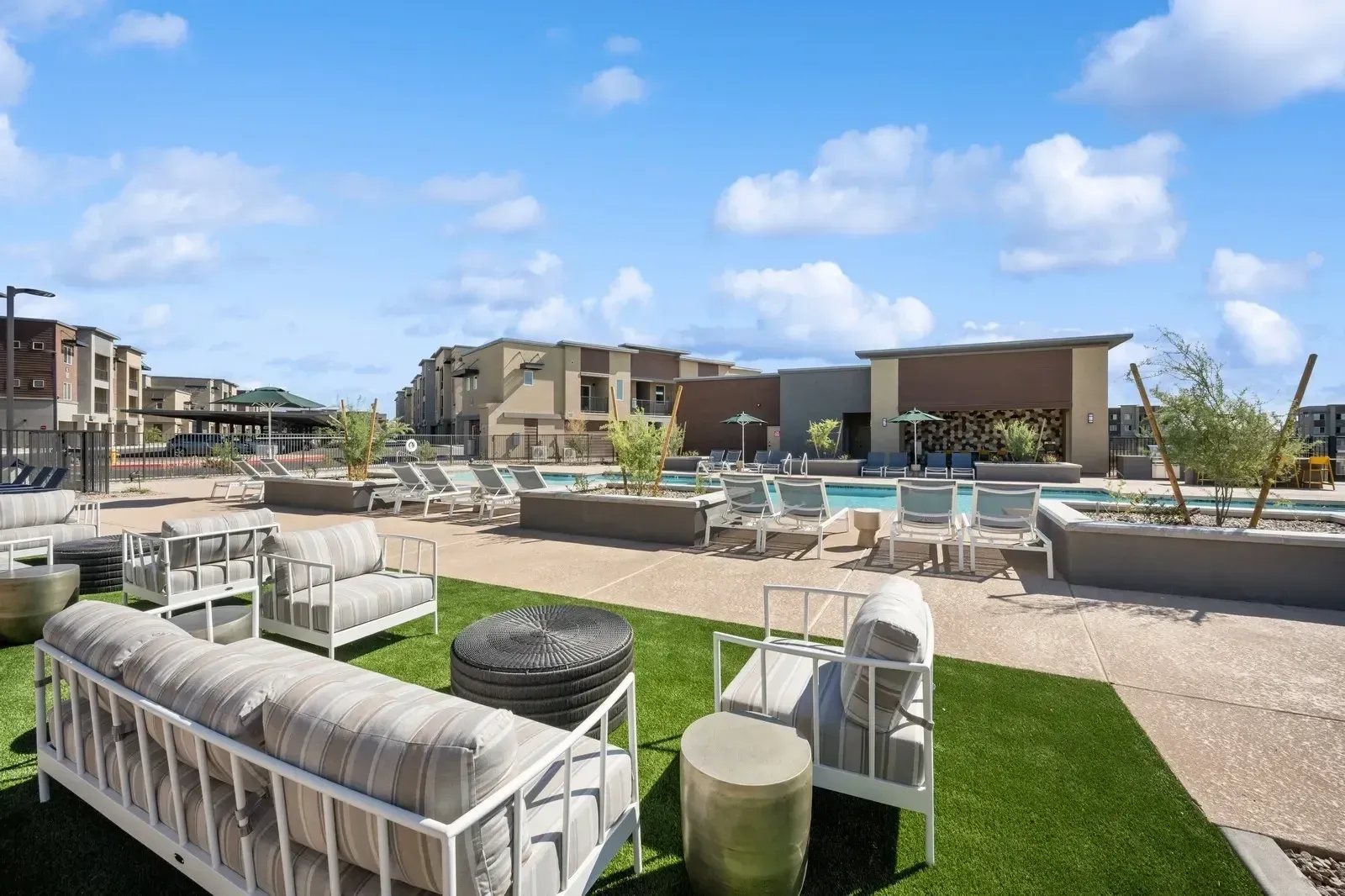 Modern apartment complex outdoor lounge area with pool and seating at Longbow Luxury apartments in Mesa, AZ.