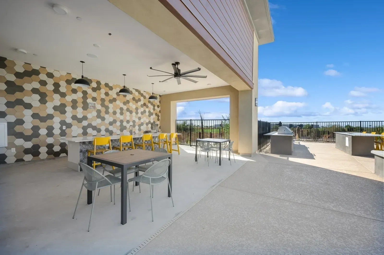 Outdoor kitchen and dining area with bar seating and grills at Longbow Luxury apartments in Mesa, AZ.